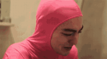 a man wearing a pink hooded suit is crying .