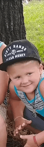 a little boy wearing a dirty hands mean money hat