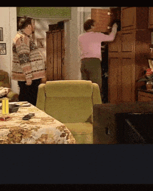 a man in a pink sweater is standing next to another man