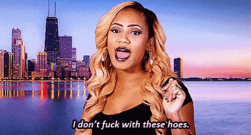 a woman is standing in front of a city skyline and says `` i don 't fuck with these hoes '' .