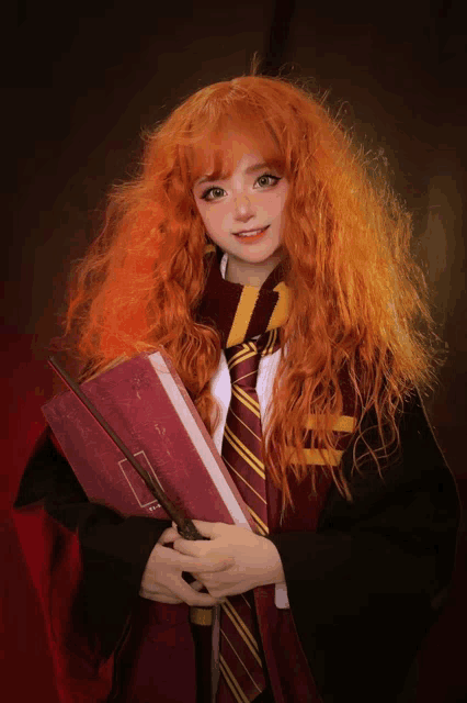 a girl in a harry potter costume is holding a book and wand