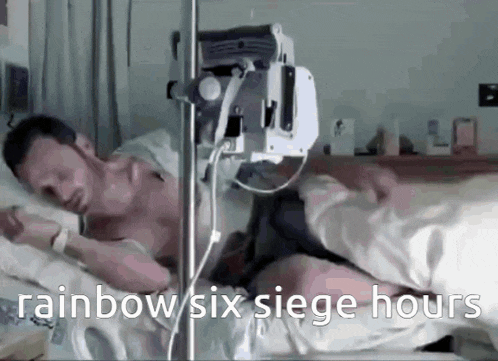 a man is laying in a hospital bed with a rainbow six siege hours written on the bottom