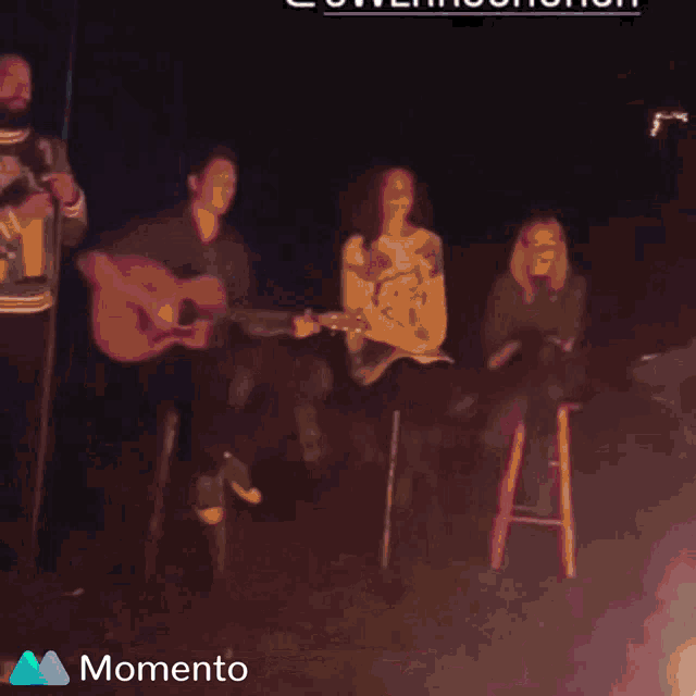 a group of people are dancing in front of a green background that says momento on it