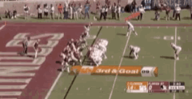 a football game is being played on a field with a banner that says 3rd & cross