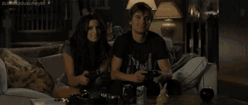 a man and a woman are playing a video game on a couch .