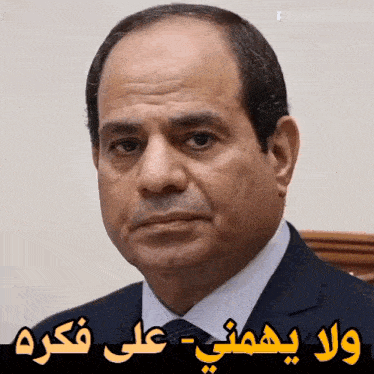 a close up of a man 's face with arabic writing above him