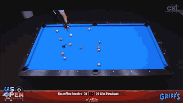 a pool table with balls on it and a man in an usa shirt