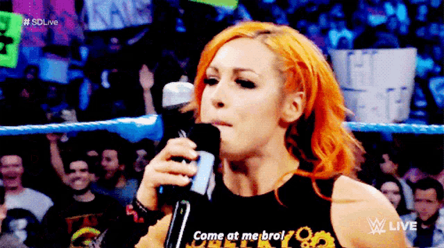 a woman speaking into a microphone with the words come at me bro on the bottom