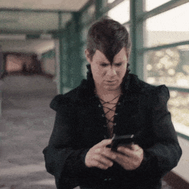 a man with a mohawk on his head is looking at his phone