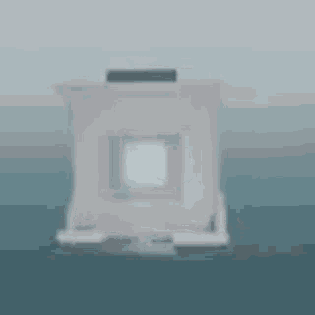 a blurred image of a white box with a handle on a blue surface .