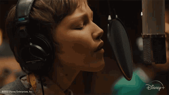 a young boy singing into a microphone with a disney logo in the corner