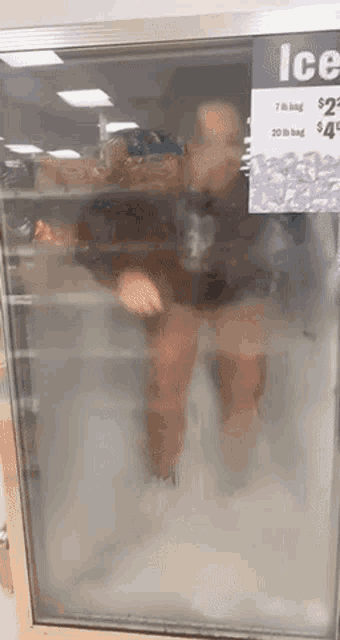 a person is standing in an ice cooler with a sign that says ice