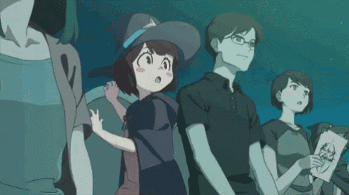 a girl in a witch hat stands next to a man in glasses