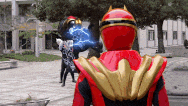 a man in a red and gold superhero costume stands in a park