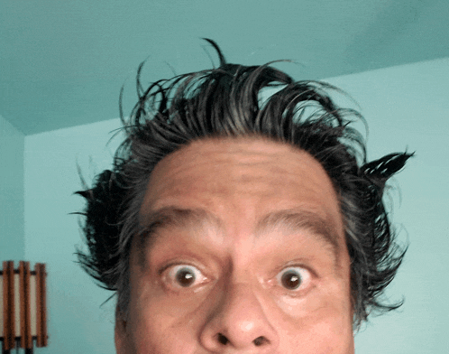 a close up of a man 's face with a very surprised look on his face