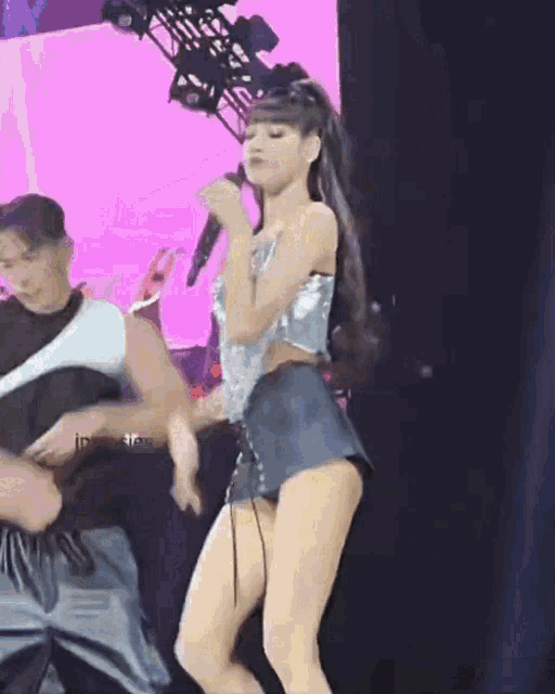 a woman is singing into a microphone on a stage