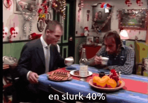 a man in a suit sits at a table with a bowl of fruit and says en sturk 40 %