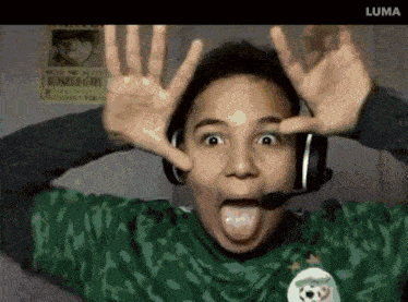 a person wearing headphones and a green shirt with a soccer ball on it making a funny face