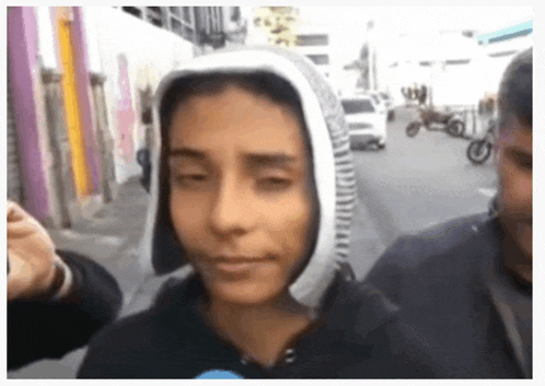 a person with a hood on their head is being interviewed