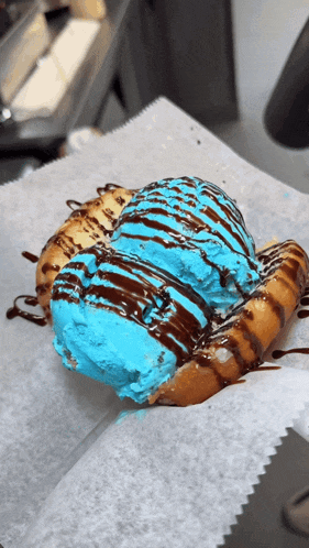 a donut with blue ice cream and chocolate sauce on top
