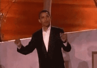 a man in a suit and tie is standing in front of a red wall .