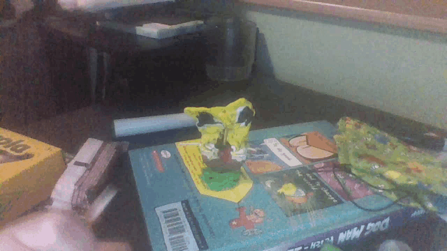 a book titled dog man fiction sits on a table next to a box of crayons