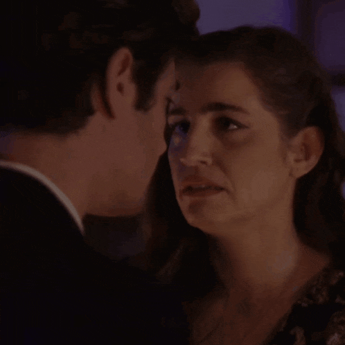 a man and a woman are kissing in the dark