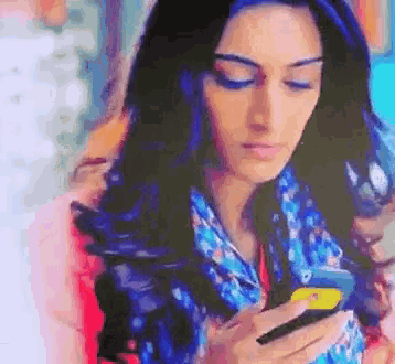 a woman wearing a scarf is looking at her cell phone
