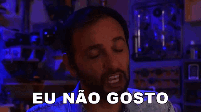 a man with a beard is saying eu não gosto in a dark room