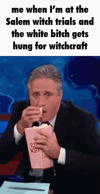 a man in a suit is eating popcorn while talking about witchcraft ..
