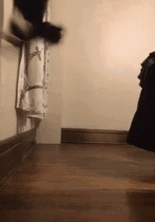 a person is standing in a corner of a room with a towel hanging on the wall .