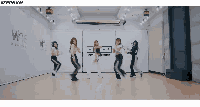 a group of girls are dancing in a room that says sec number on the wall