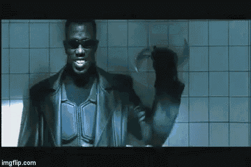 a man in a leather jacket and sunglasses is standing in a bathroom holding a knife .