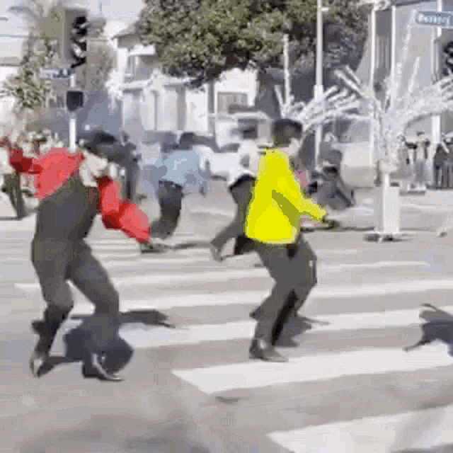 a group of people are dancing in the street while crossing the street .