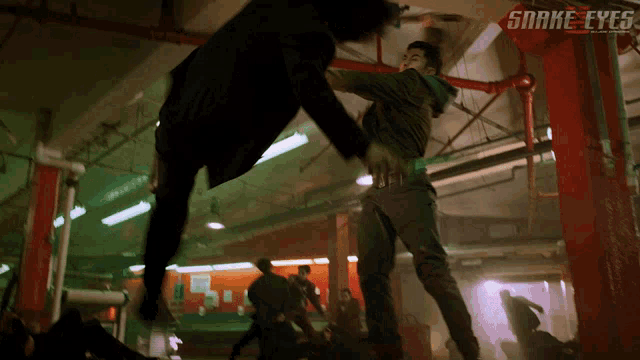 a movie poster for snake eyes shows a man kicking another man