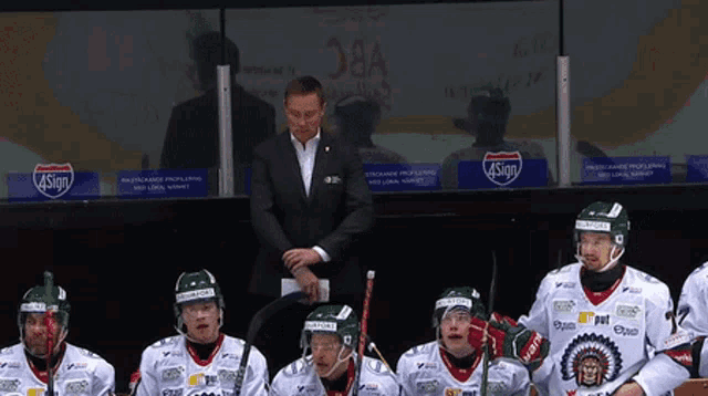 a group of hockey players sitting in a locker room with a sign that says 4sign on it
