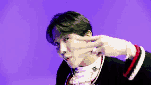 a close up of a man making a peace sign with his hands .