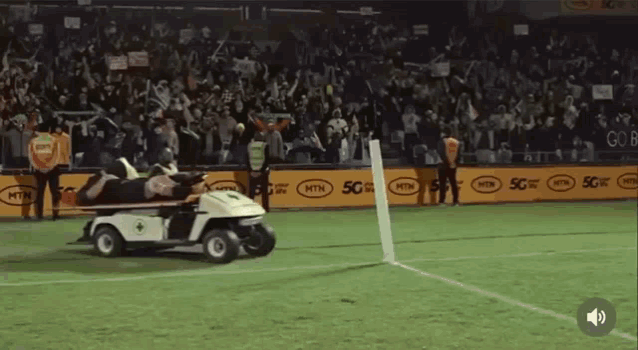 a golf cart is on a soccer field with mtn advertisements on the sidelines
