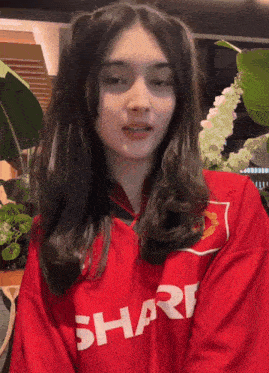 a woman wearing a red shirt that says shar on it