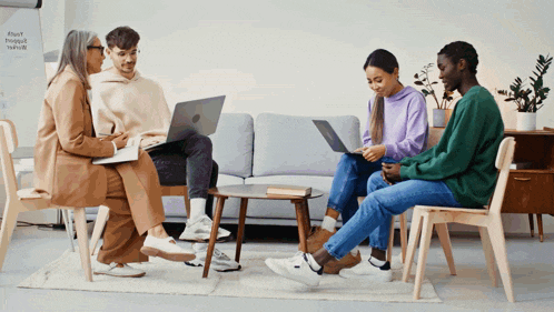 a group of people are sitting around a table with laptops in front of a white board that says #happy #productive #healthy