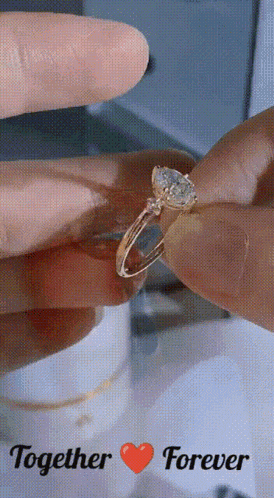 a close up of a person holding a ring with the words together forever on the bottom
