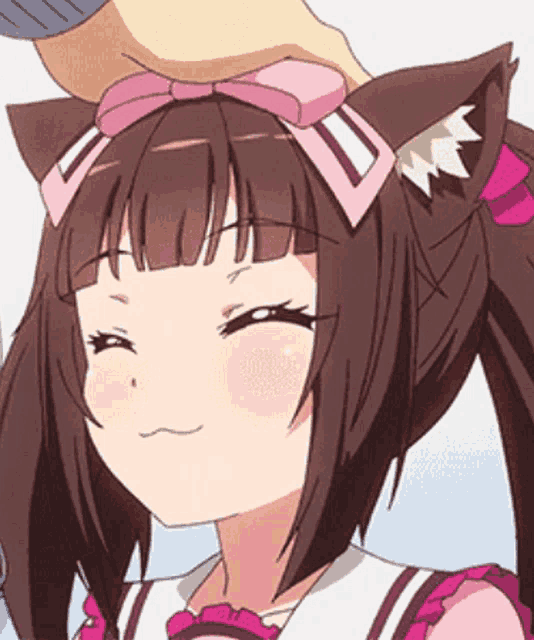 a person is putting a pink bow on the head of a girl with cat ears