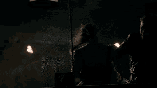 a close up of a man 's face in the dark with a light behind him