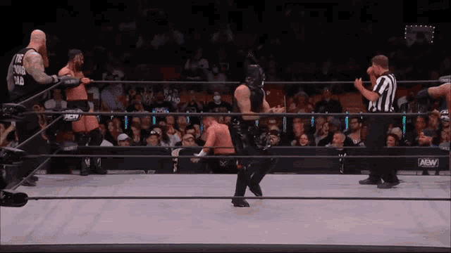 a wrestler wearing a black shirt that says " the young blood " stands in a wrestling ring