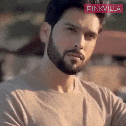 a man with a beard is wearing a pinkvilla t-shirt
