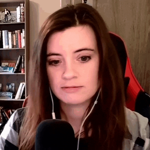 a woman wearing headphones and a microphone looks at the camera .