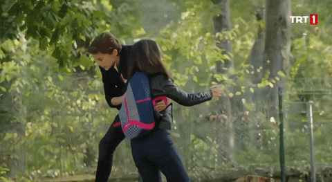 a man and a woman are fighting in front of a trt 1 logo