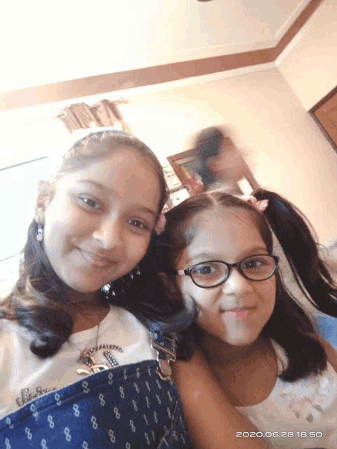 two young girls are posing for a picture and the date is written in the corner