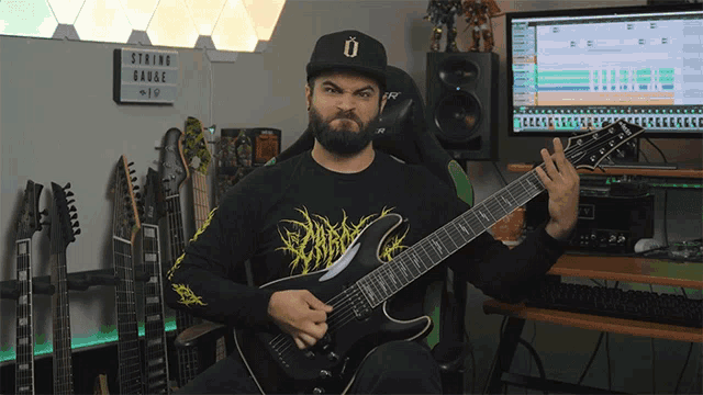 a man playing a guitar in front of a sign that says " string gauge "