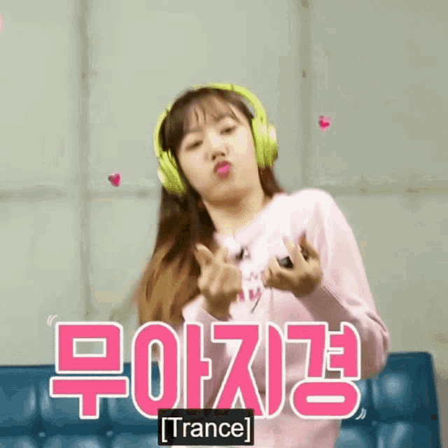a girl wearing headphones is making a heart shape with her fingers and the word trance is on the bottom right
